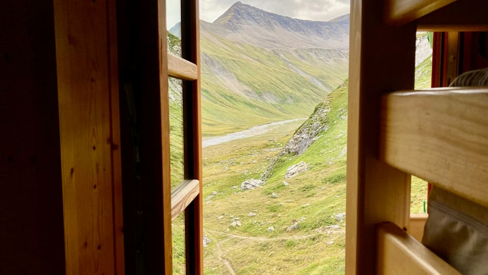 A mountain view from a window with a path below.
