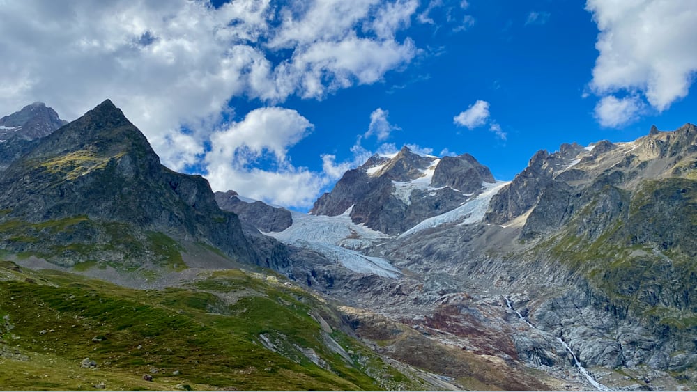 A mountain with an ice cap and a blue sky in the background.