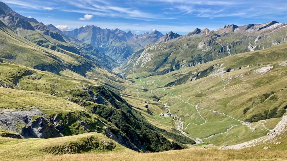 A valley with mountains in the background and a road going through it.