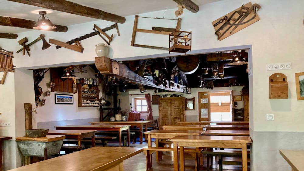 A restaurant with many tables and benches, some of which are empty.