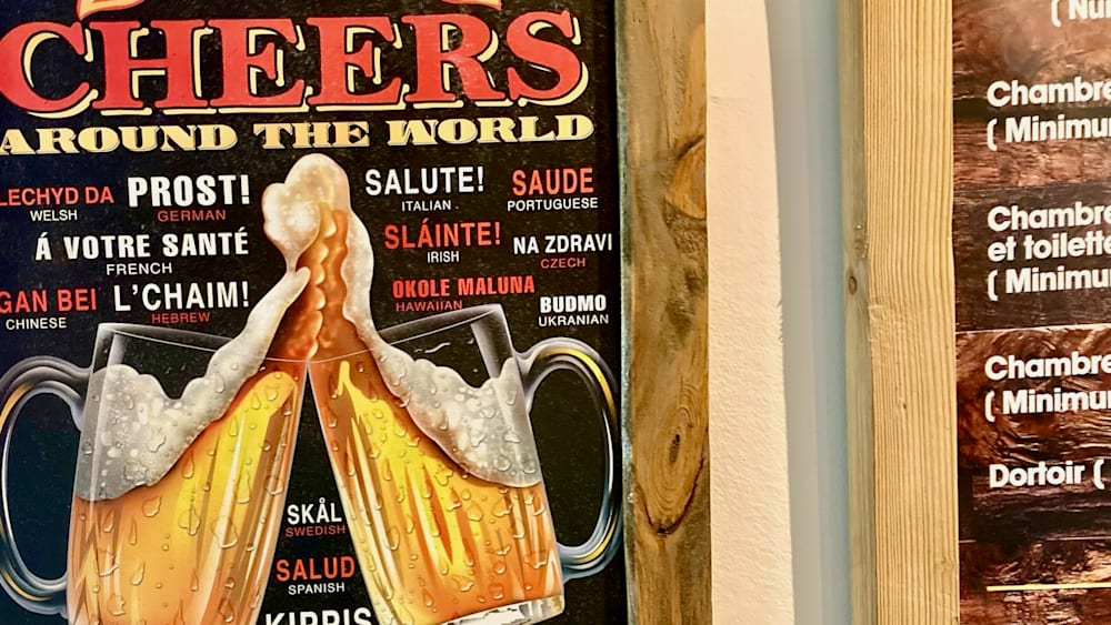 A framed sign that is titled "The World of Beer" with different types of beer listed on it.