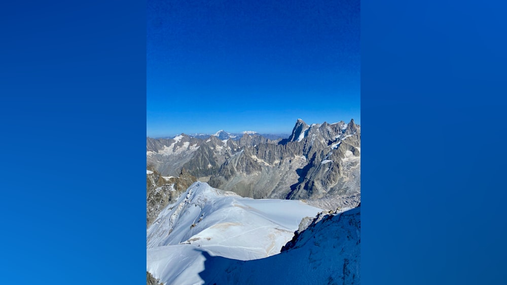 A mountain with snow on top and a clear blue sky in the background.