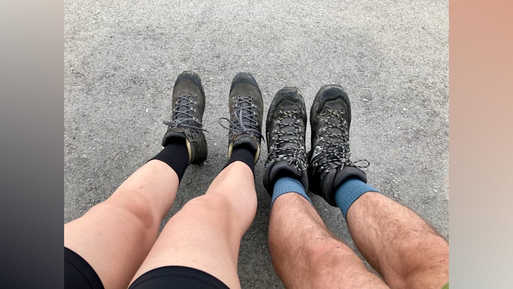 Two people with muddy boots sitting next to each other.