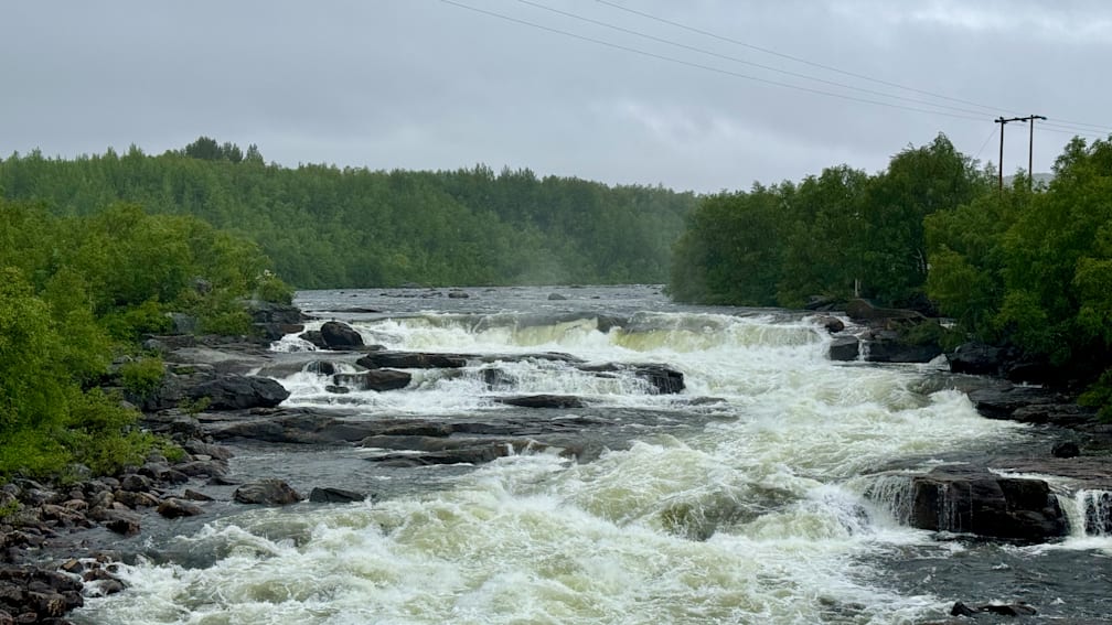 A river of water is very high and is crashing down the side of a cliff.
