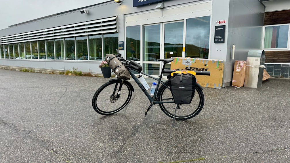 A black trek bike on a street next to a building.