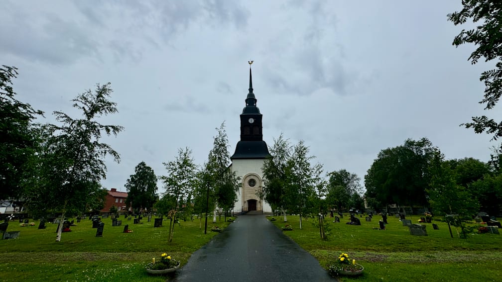 A large white church with a clock tower and a spire in the middle of it.