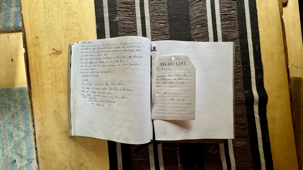 A to do list is sitting on top of a note pad that is open to a page in a book.