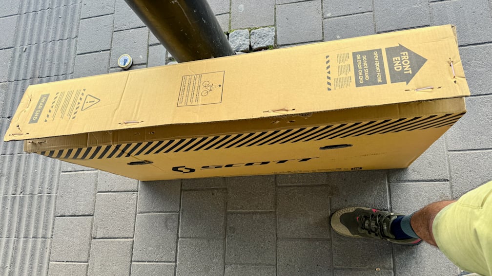 A pair of shoes and a box on the ground.