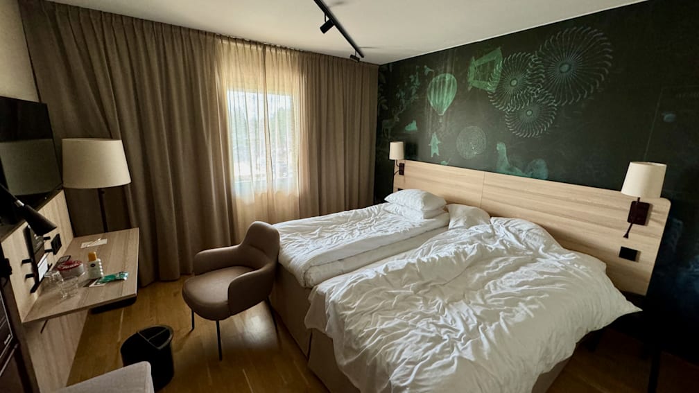 A hotel room with a bed and a chair in it.