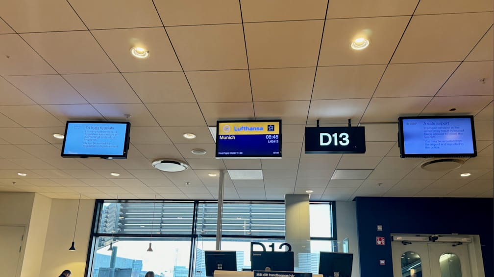 A Lufthansa infomation screen is above a D13 sign.