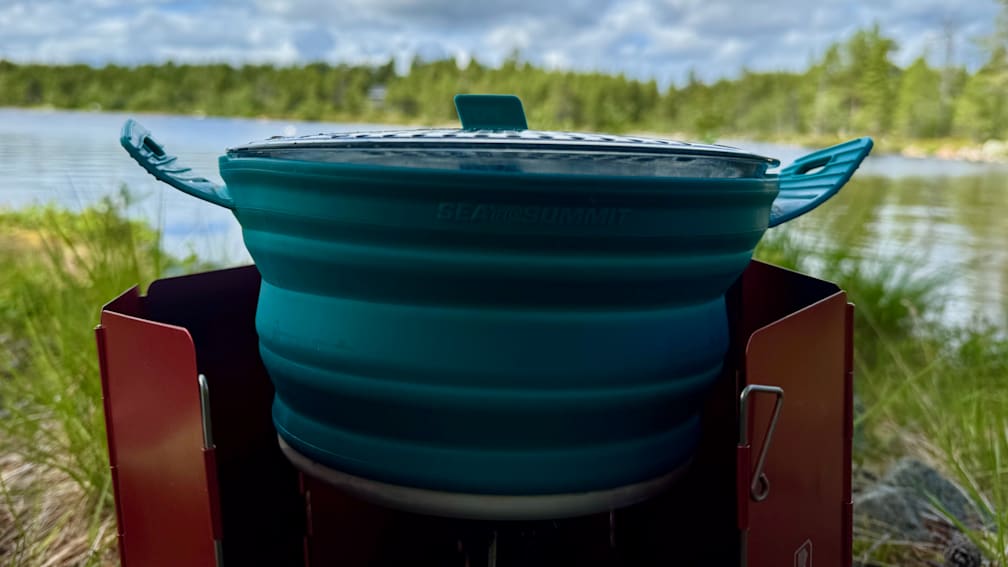 A blue container that is folded up and sitting on a stove.