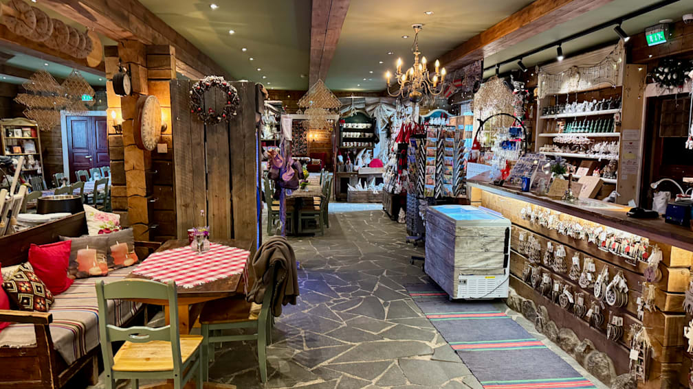 A large room has tables and chairs set up and a large refrigerator in the corner.