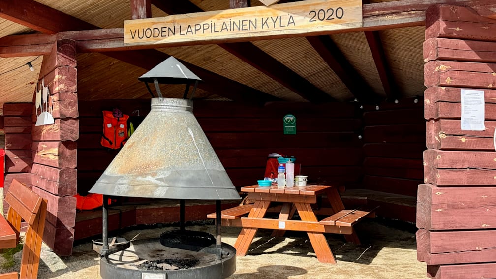 A sign above a picnic table says Vouden lapilainen kyla.