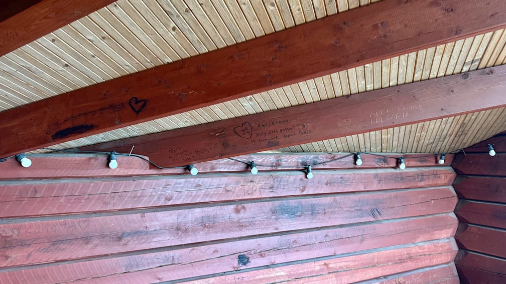 A wooden beam has a heart on it and says "ti j'ai bien fait" at the bottom.