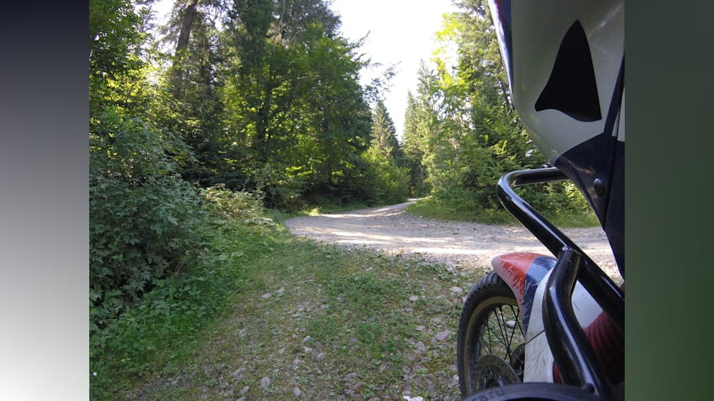 A dirt bike is on a path that goes around a curve.