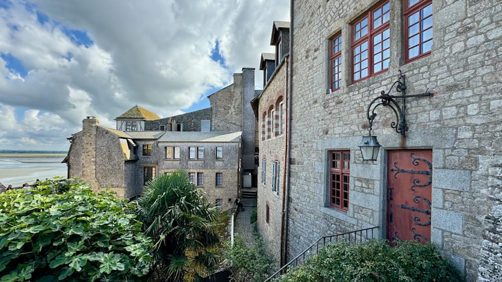 A view of a brick building from a cobblestone alley way.