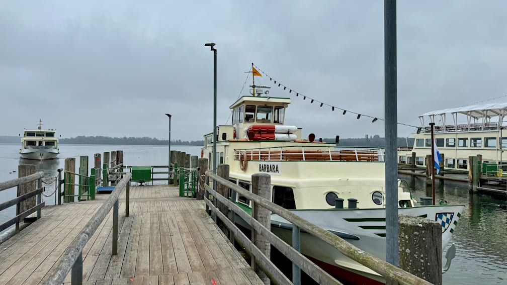 A boat named Barbara is docked in the marina on a cloudy day.