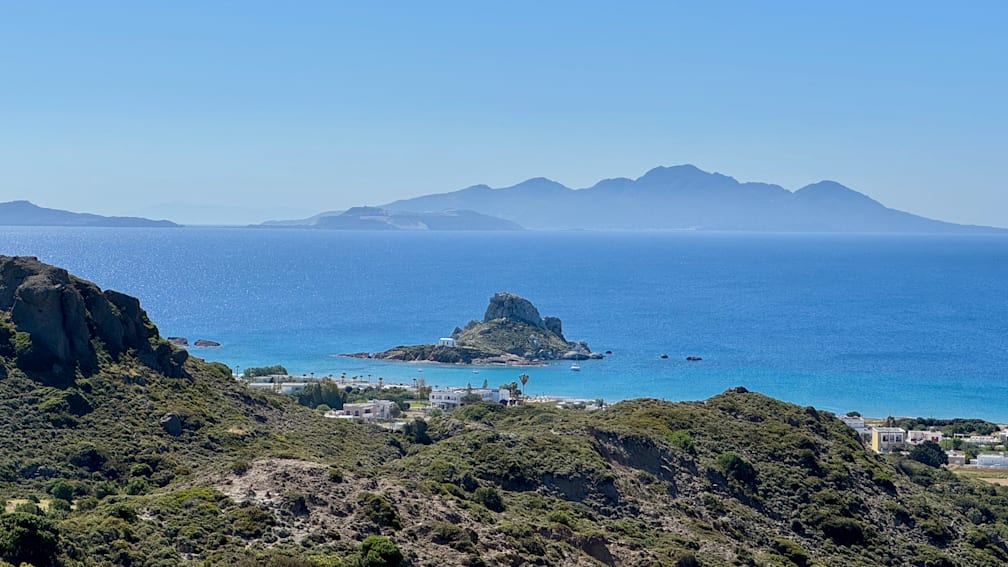 a boat on the water with a small island in the middle.