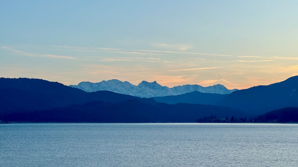 A beautiful blue lake with mountains in the distance.