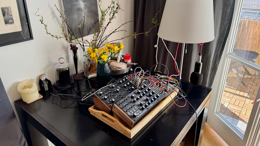A sound board with many wires and a lamp with a vase of flowers next to it.