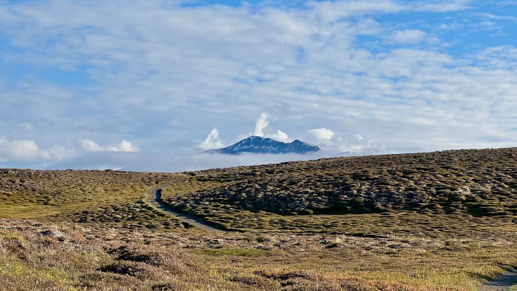 A mountain with a path going up and down it.