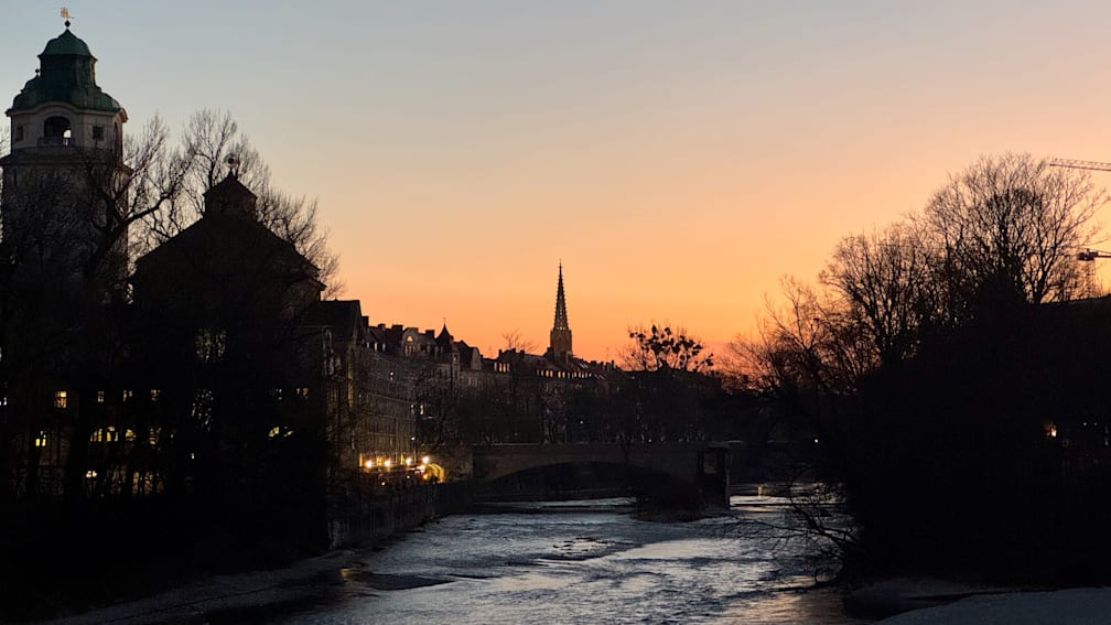 A bridge over a river with a cathedral in the background.