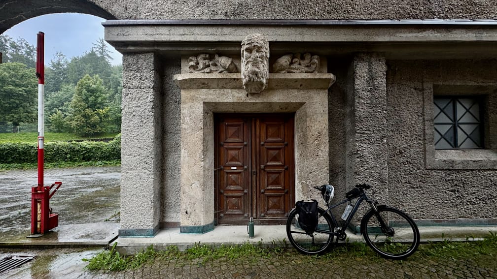 A bicycle parked in front of a building with a large wooden door.