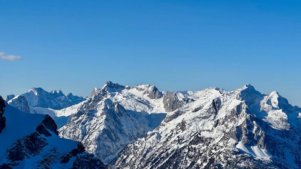 A mountain with snow on top and a clear blue sky in the background.