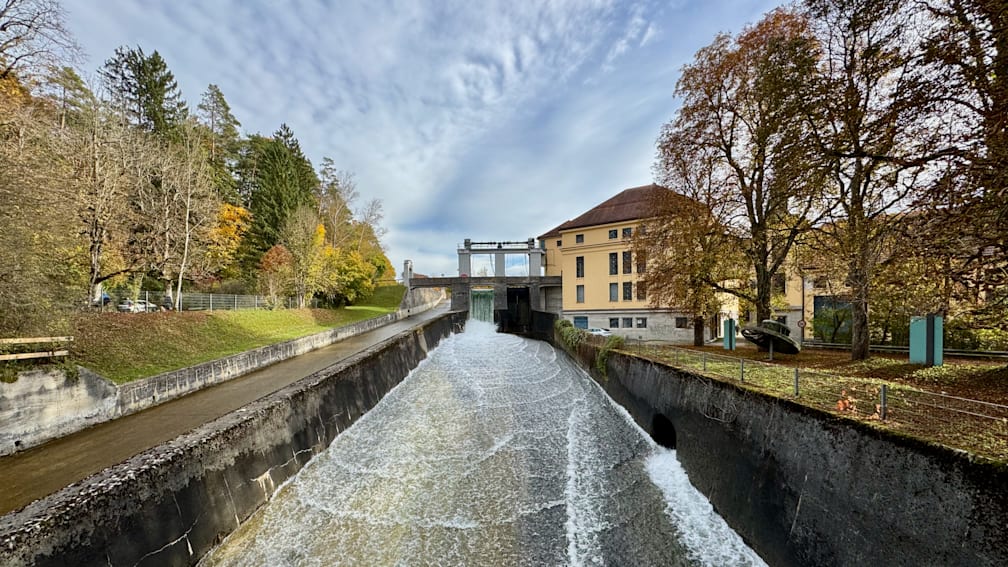 A large body of water is flowing through a long, narrow passageway with splash outs on either side.