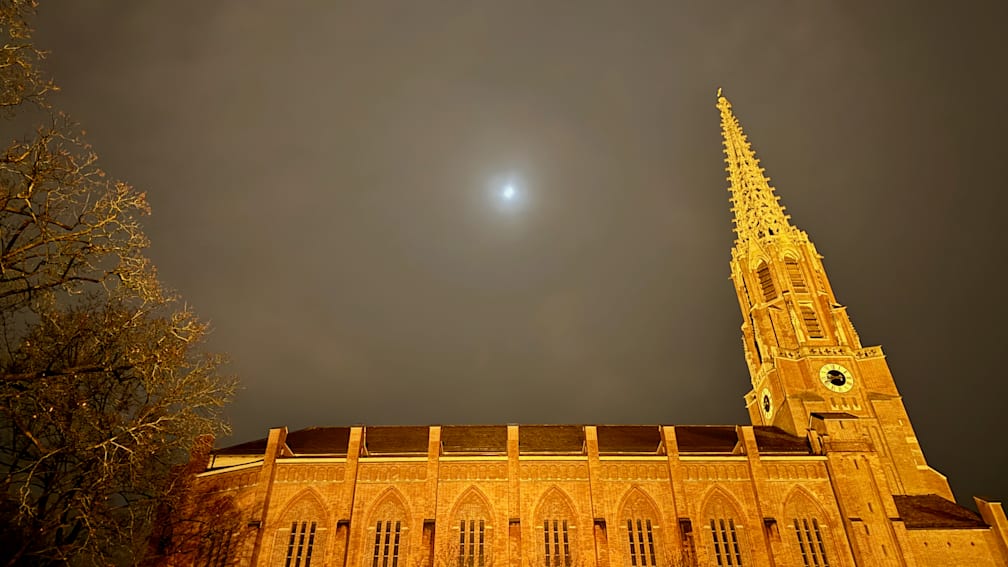 A church with a clock that reads 11:20 on its face.
