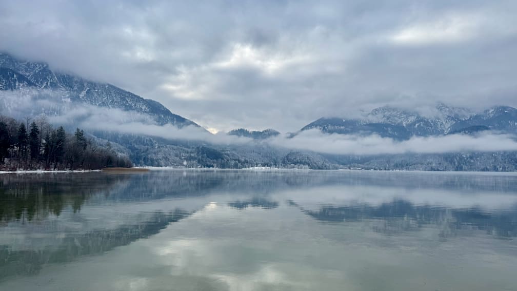 A lake is shown with trees in the background and it's reflection is visible.