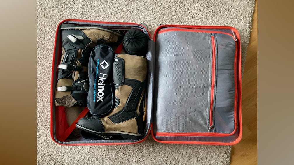 The inside of a suitcase with Heimox and other items in it.