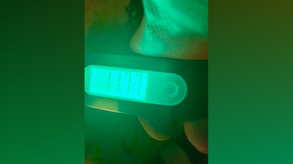 A digital watch with the time displayed of 11:57.