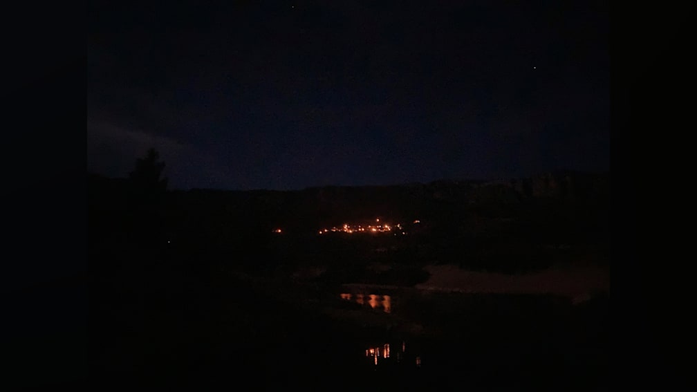 A dark sky filled with stars and a small town in the background.