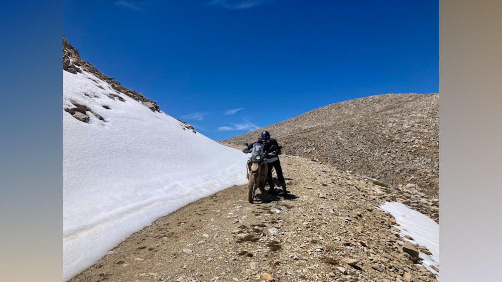 A man on a dirt bike on the side of a mountain.