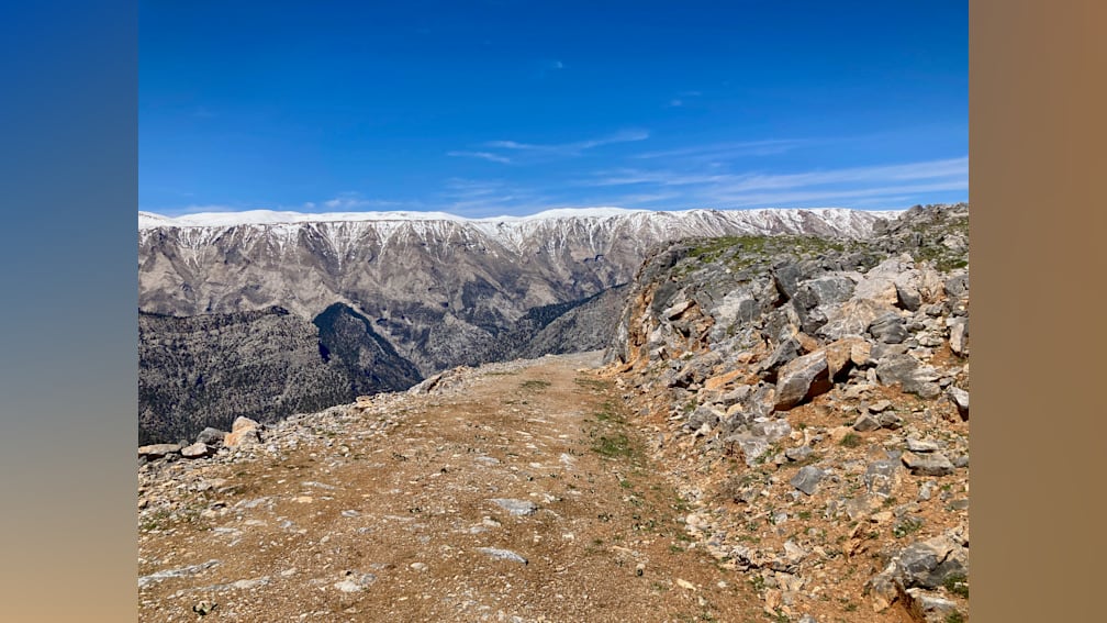 A rocky path winds up the side of a mountain.