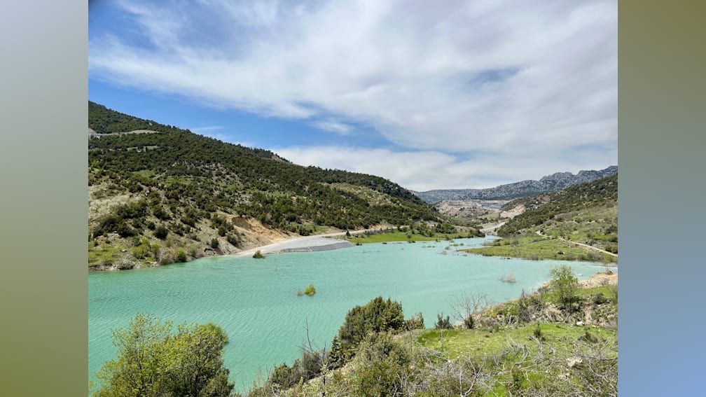 A beautiful view of a lake surrounded by hills and trees.