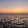 A sunset over a large body of water with the water appearing very dark.