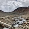 A stream of water runs down some rocks in a deserted area.