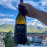 A bottle of Pitzner Lagrangeisch has been held up in front of a mountain range.