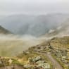 fog blankets the mountains and the path leading to the top.