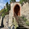 A set of stairs lead to a small arch door.
