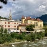 A river runs next to a building and a church steeple.