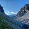 A valley with a mountain in the background is full of rocks.