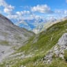 A valley with grass and a mountain in the background.