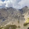 A foggy mountain with a rocky peak and a valley below.