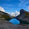 A large lake with a mountain in the background and a large body of water reflecting the sky.