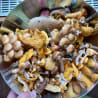 A person holding a bowl of mushrooms with a few pieces missing.