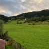 A fenced in field with a house in the background.