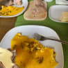 A plate of food with a fork on a table with a green placemat underneath.